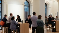 people standing and seated in meeting space