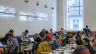 people studying at long tables in a bright room