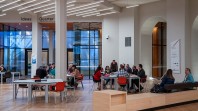people seated at tables in information centre