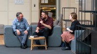 three seated people chatting