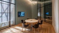A round table encircled by six empty chairs