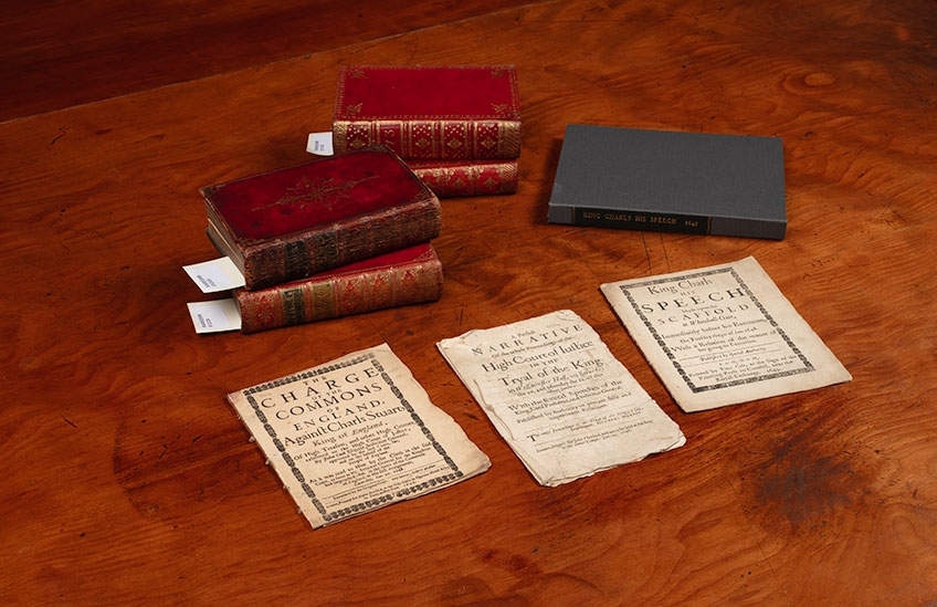 Image of rare books and pamphlets from the John Emmerson Collection at State Library Victoria placed on a brown table. There are five books and three pamphlets. 