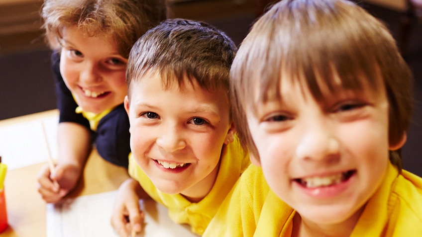 Smiling young schoolboys wearing yellow T-shirts