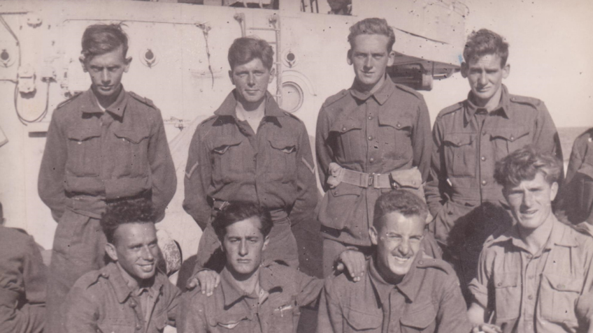 A black and white photo of a group of soldiers standing together on the HMS Kimberley. 