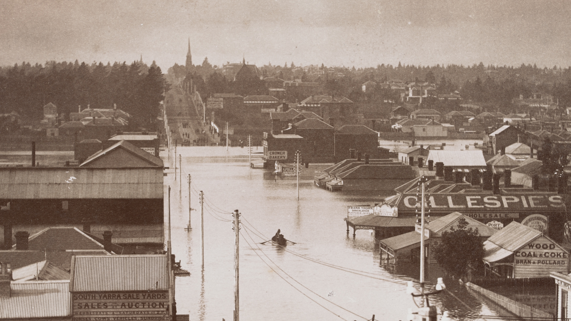 A single row boat floats down a flooded Melbourne street