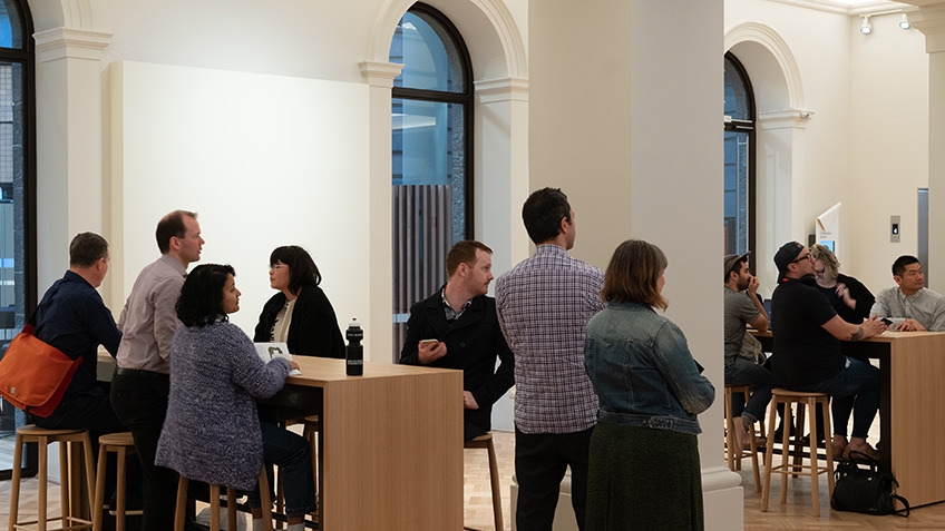 people standing and seated in meeting space