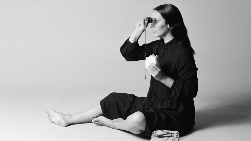 Black and white photo of a woman looking through binoculars