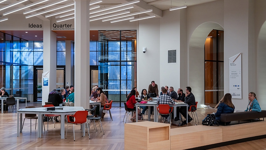 people seated at tables in information centre