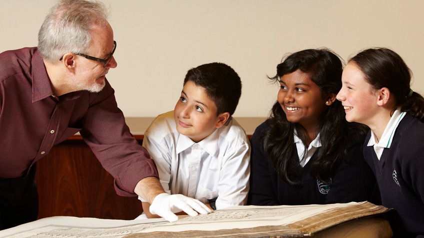 A man teaching three children