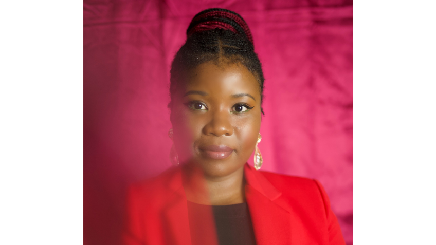 A woman in a red coat smiling at the camera