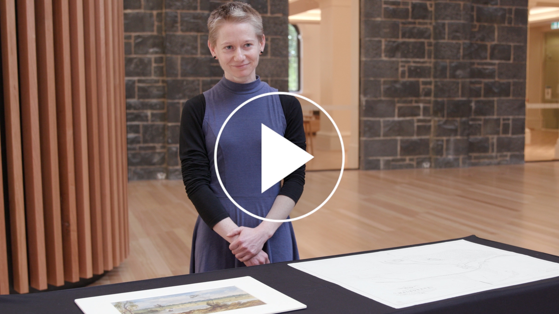 Woman standing in front of a table with maps on it