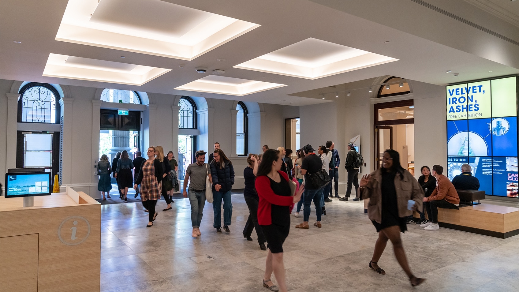 people walking through library foyer