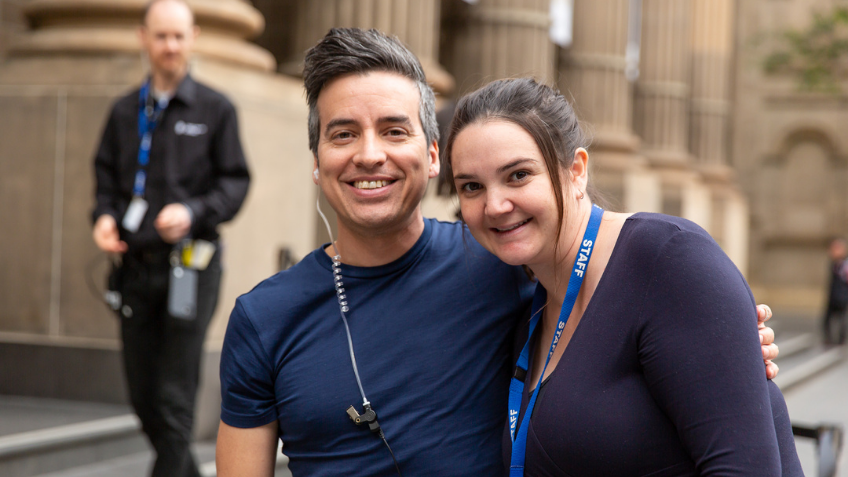Two people with staff tags on smiling at the camera