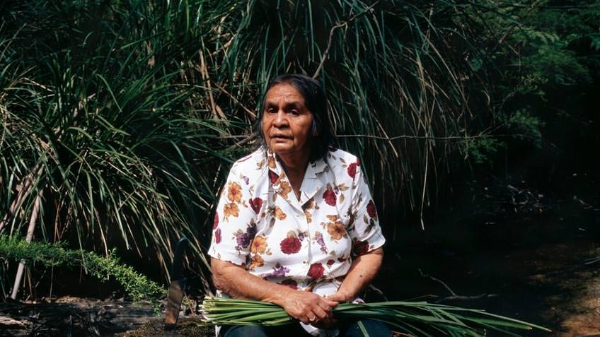 Portrait of elder Eadie Terrick weaving a basket; photo by Angela Lynkushka, 20