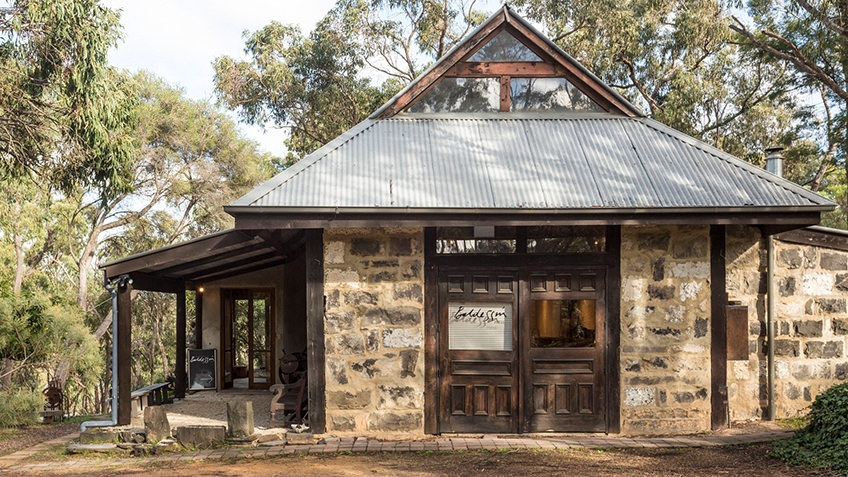 bluestone studio with tin roof surrounded by bushland