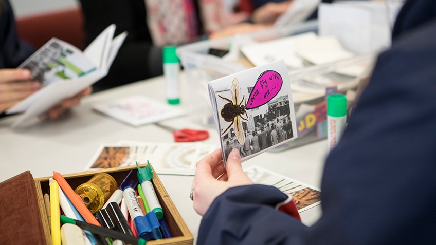 materials including pens, glue and paper cutouts being prepared for a zine