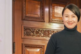 smiling woman outside ornate door