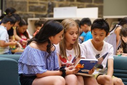 three teenagers reading a book