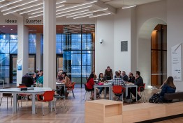 people seated at tables in information centre