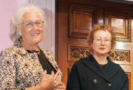 two smiling women outside ornate wooden door