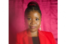 A woman in a red coat smiling at the camera