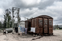 A burnt out train carriage with grey skies behind it