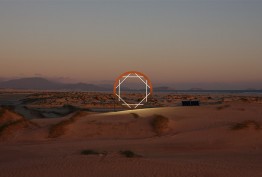 Australian outback coastal scene at dawn or dusk with sand in foreground and low mountains in background