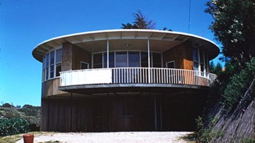 round modernist house with railings and driveway