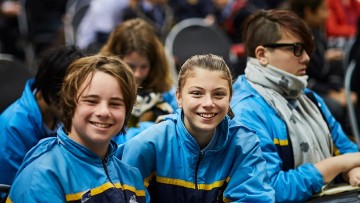 Smiling boy and girl in an audience of secondary school students