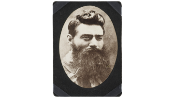 Black and white headshot photograph of Ned Kelly, a man with dark hair and long beard.