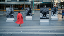 Woman with red dress in front of artworks at State Library Victoria 