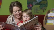 Photograph of mother reading a story to child