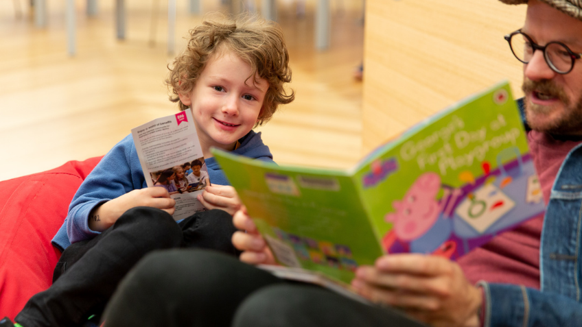 Man and young boy reading a book together