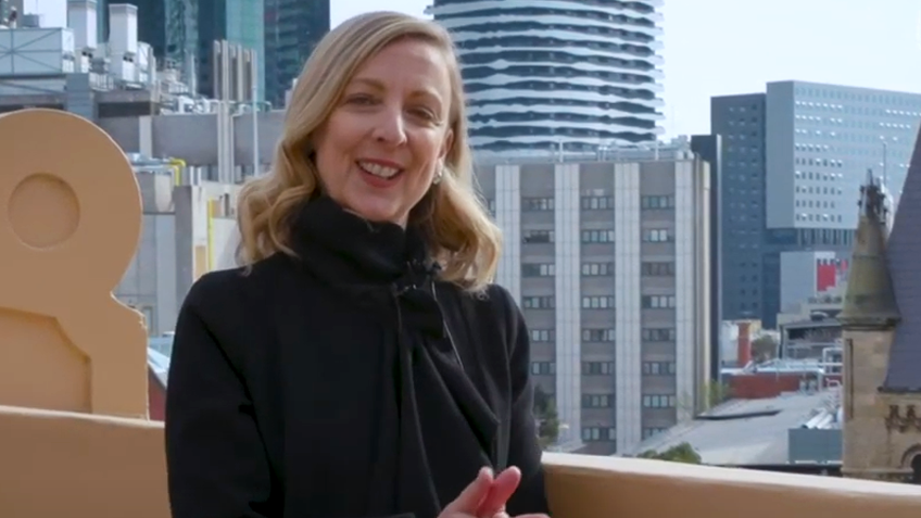 A woman in black clothes with city skyscrapers in the background