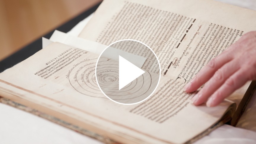 An open book with a play button on top
