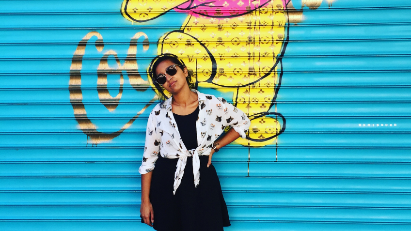 Woman standing in front of a blue wall